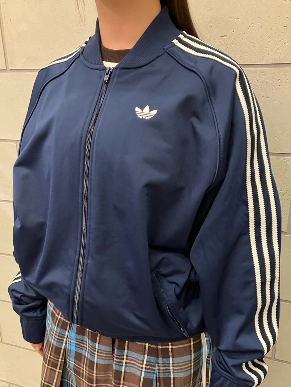 ブラウン系のスカート、ブルー系のジャージ、ブルー系のデニムパンツを着用したレディースの冬コーディネートの2枚目の写真