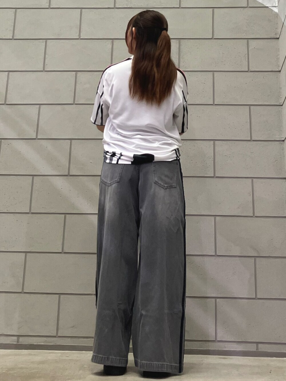 ホワイト系のTシャツ/カットソー、グレー系のデニムパンツ、ブラック系のスニーカーを着用したレディースの夏コーディネートの3枚目の写真