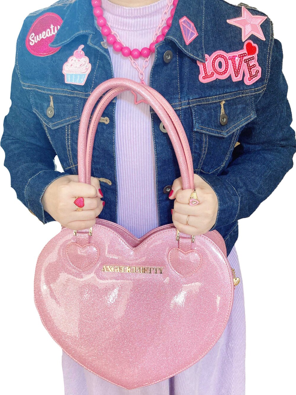 ピンク系のハンドバッグを着用したレディースの冬コーディネートの2枚目の写真