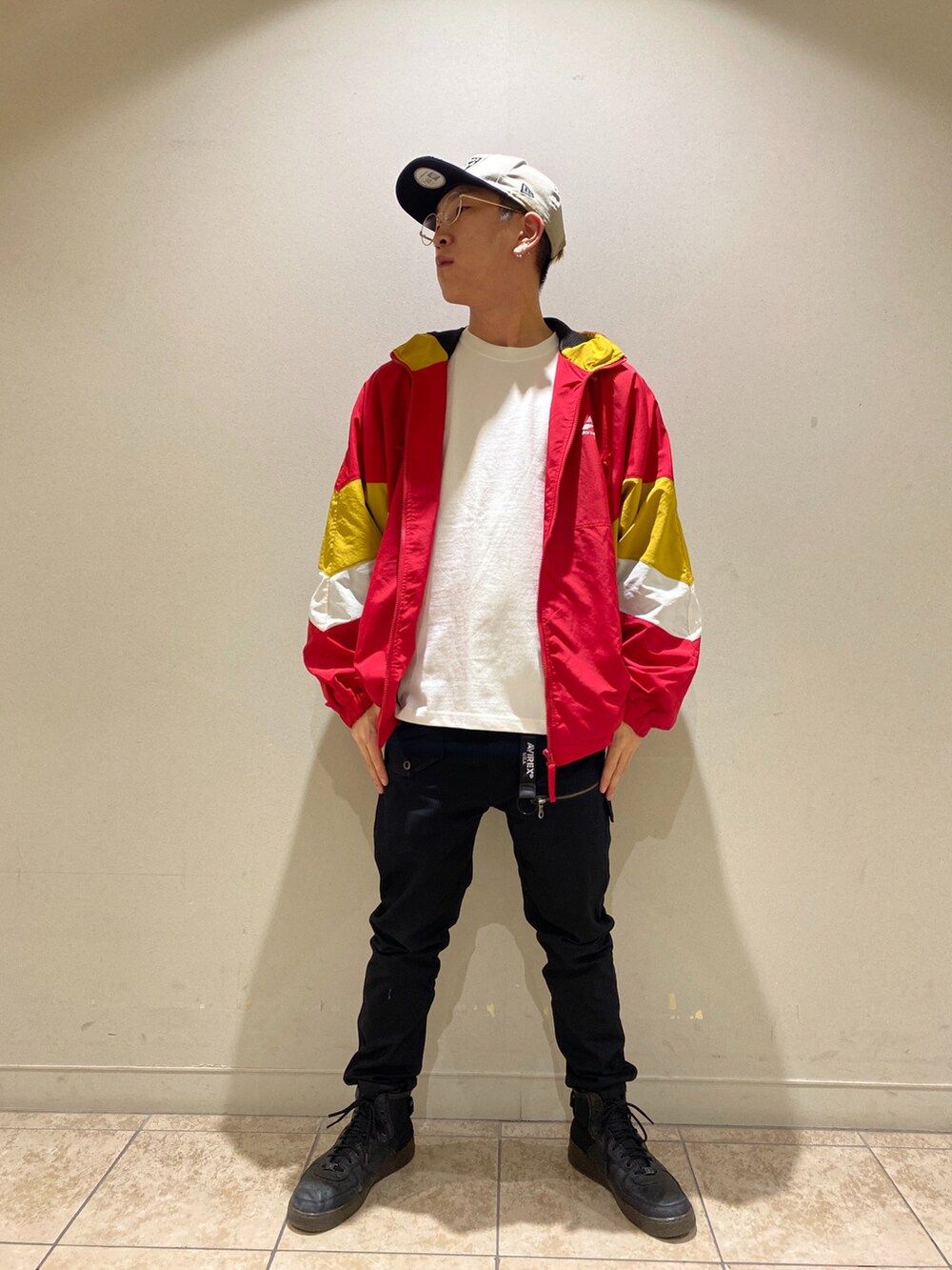 レッド系のナイロンジャケット、ブラック系のパンツ、ホワイト系のTシャツ/カットソーを着用したメンズの夏コーディネートの3枚目の写真