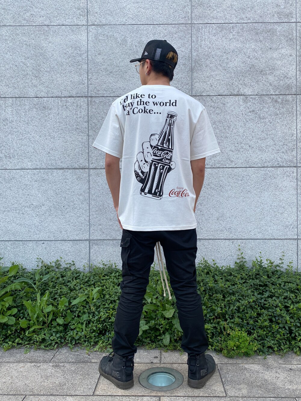 ブラック系のパンツ、ホワイト系のTシャツ/カットソー、ブラック系のキャップを着用したメンズの夏コーディネートの2枚目の写真
