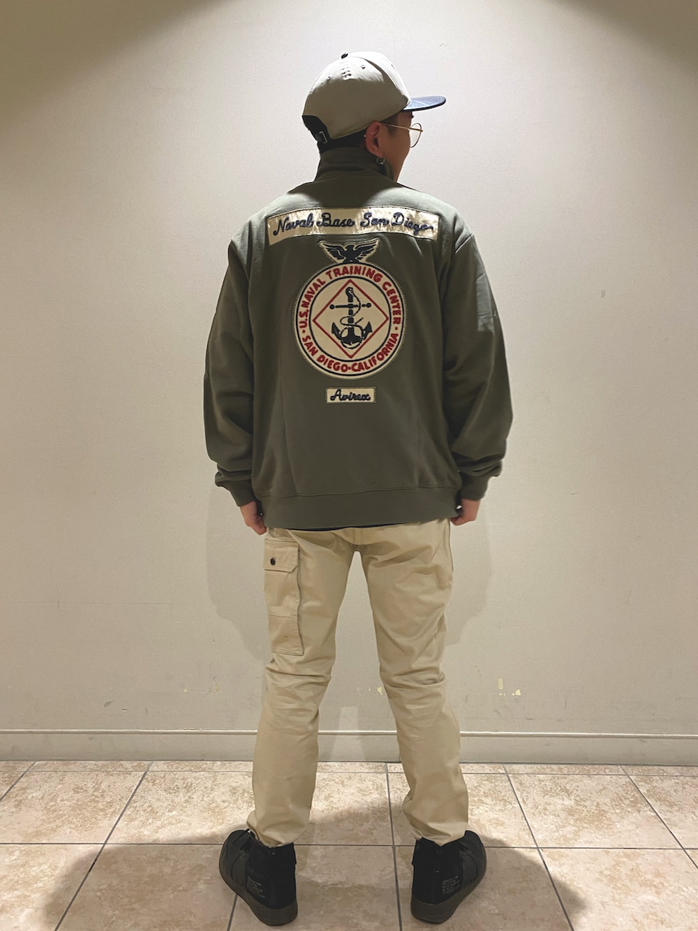 ベージュ系のパンツ、グリーン系のジャージ、ブラック系のTシャツ/カットソーを着用したメンズの春コーディネートの3枚目の写真