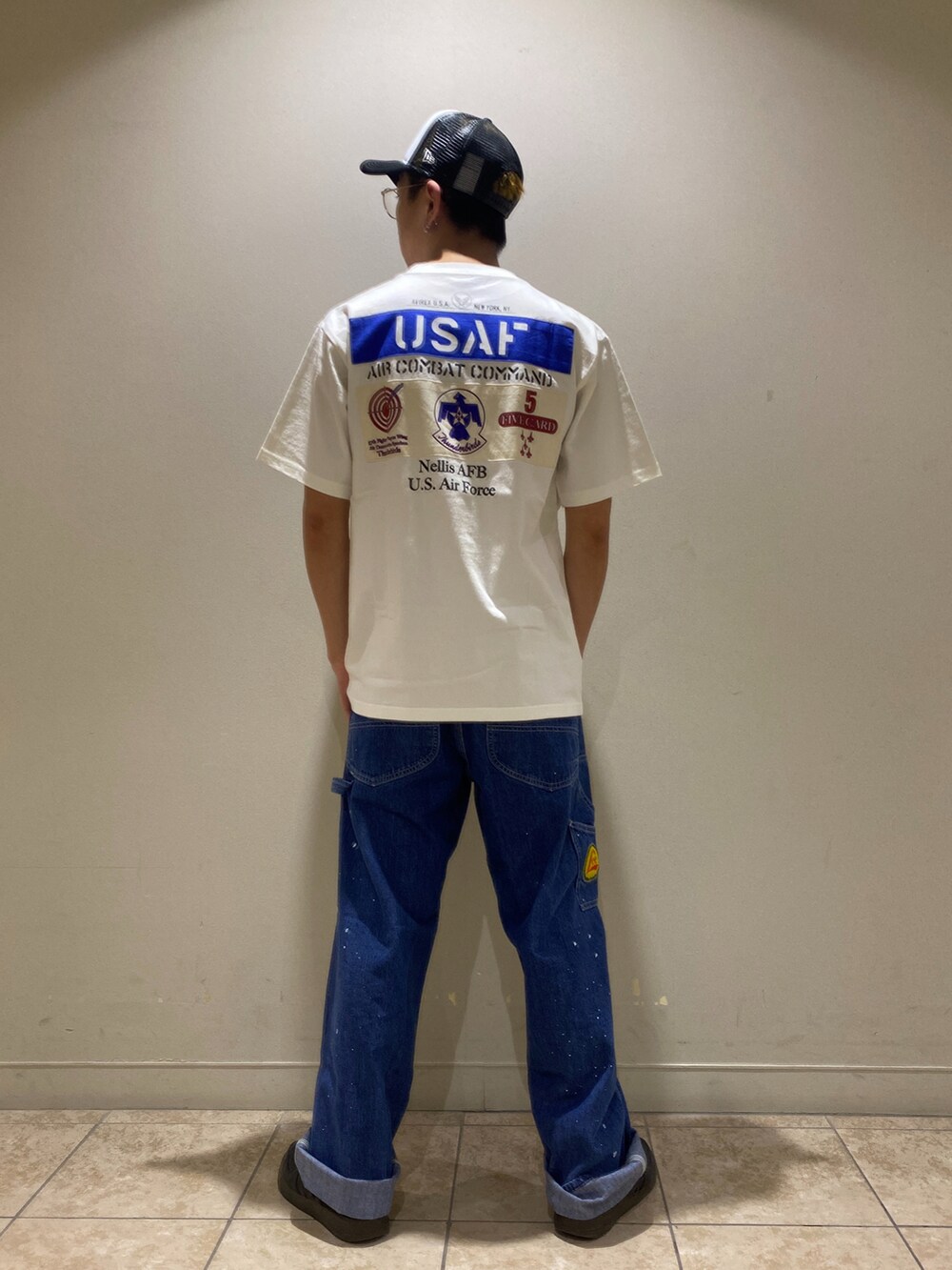 ホワイト系のデニムパンツ、ホワイト系のTシャツ/カットソー、ブラック系のキャップを着用したメンズの夏コーディネートの2枚目の写真