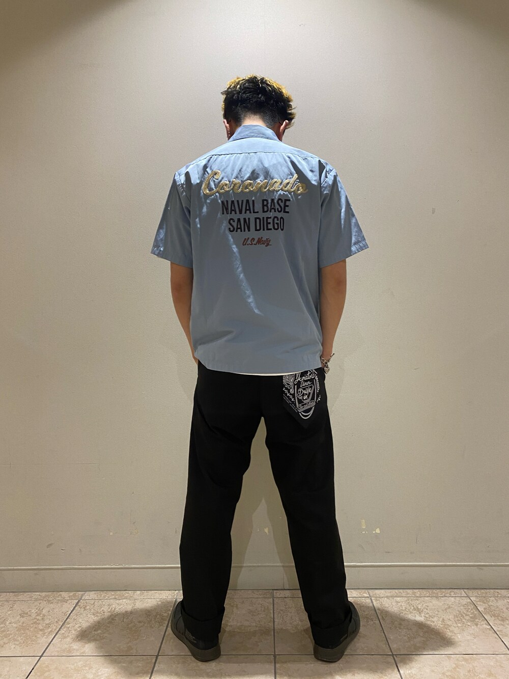 ブラック系のチノパンツ、ブラウン系のシャツ/ブラウス、ホワイト系のTシャツ/カットソーを着用したメンズの春コーディネートの2枚目の写真