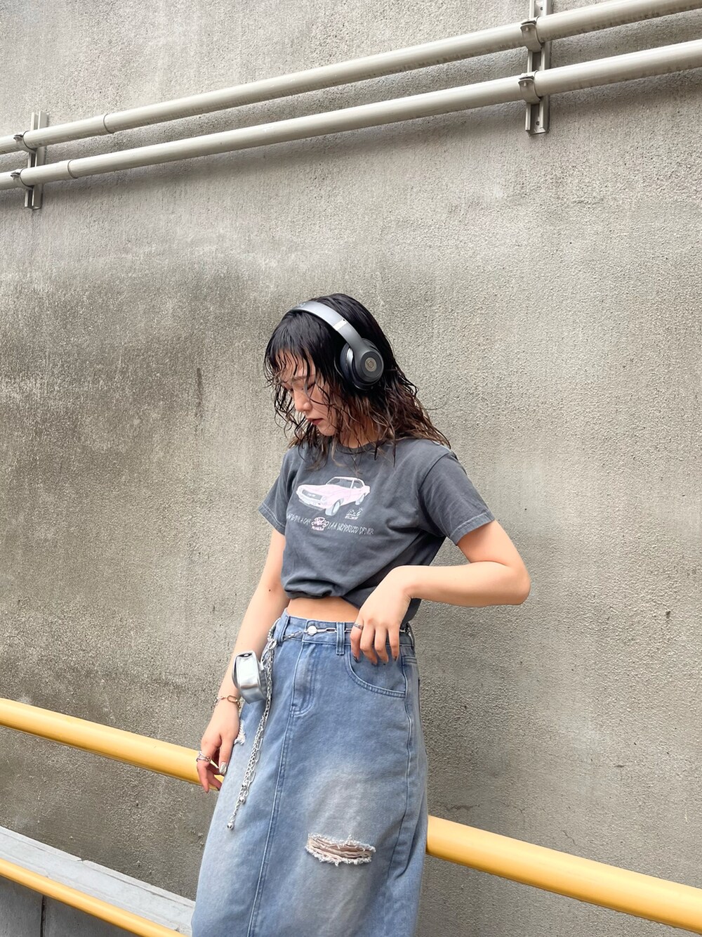 グレー系のTシャツ/カットソー、ブルー系のデニムスカート、ブラック系のブーツを着用したレディースの春コーディネートの2枚目の写真