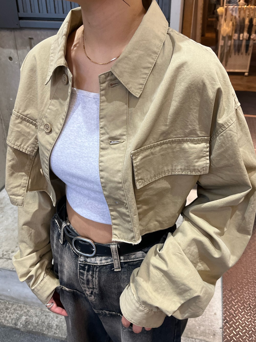 ベージュ系のミリタリージャケット、グレー系のキャミソールを着用したレディースの夏コーディネートの5枚目の写真