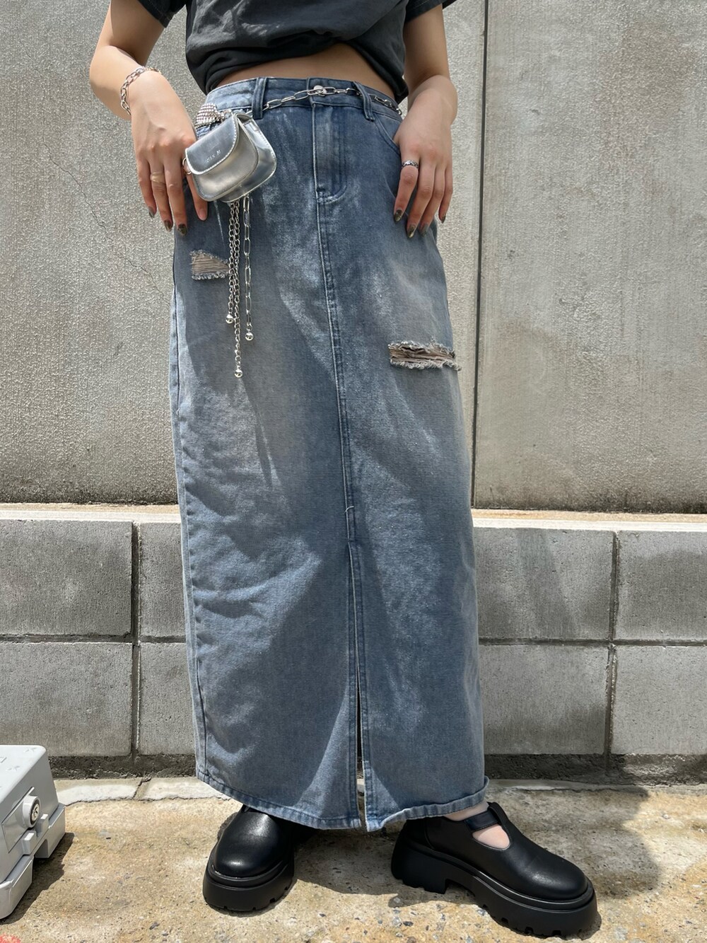 グレー系のTシャツ/カットソー、ブルー系のデニムスカート、ブラック系のブーツを着用したレディースの春コーディネートの3枚目の写真