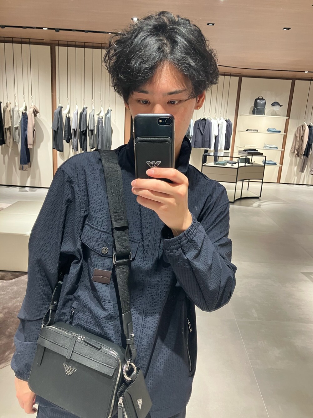 ブルー系のその他パンツ、ブルー系のナイロンジャケット、ブラック系のショルダーバッグを着用したメンズの夏コーディネートの2枚目の写真