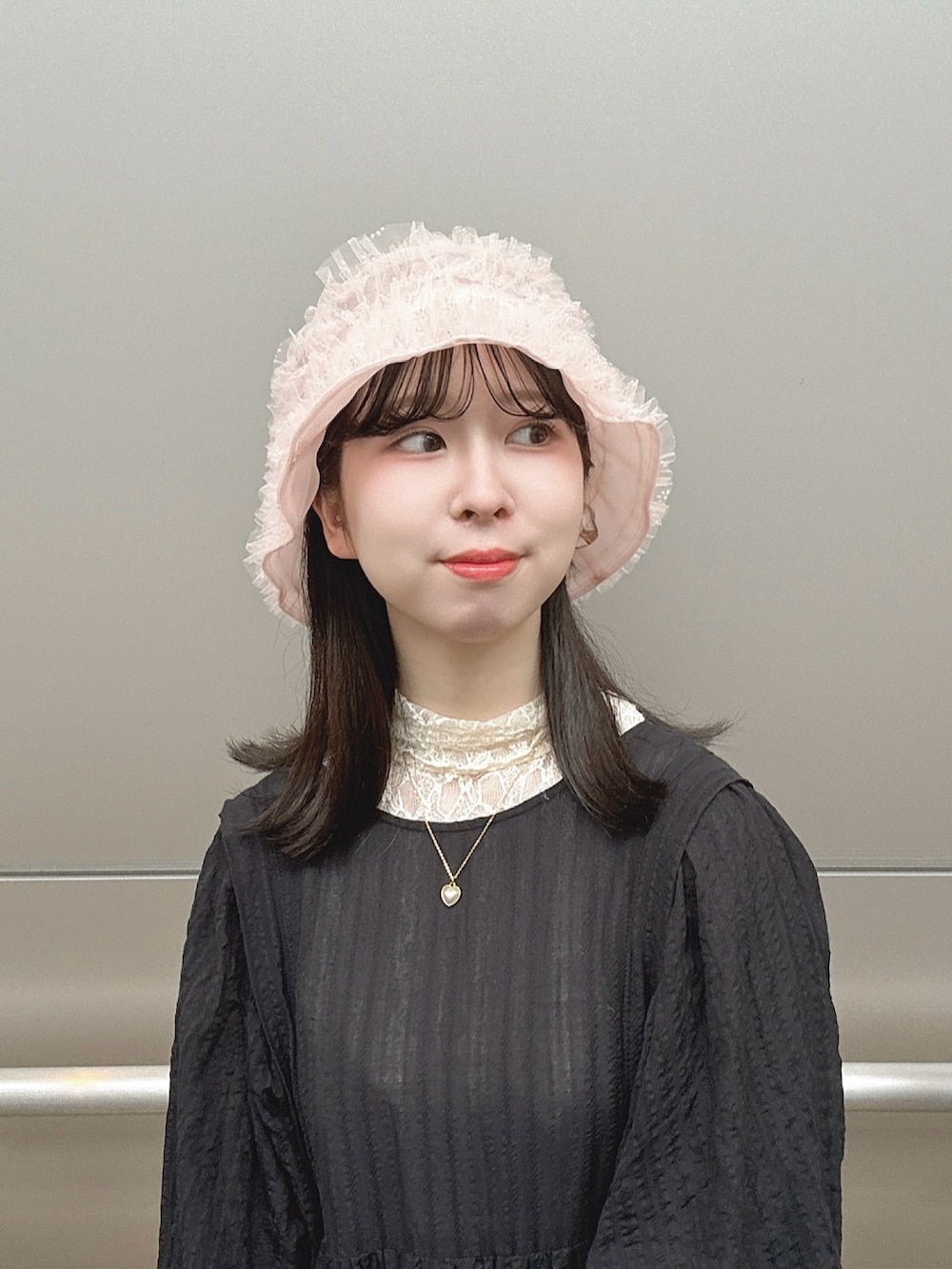 ピンク系のハットを着用したレディースの夏コーディネートの3枚目の写真