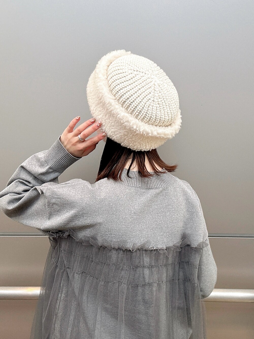 ホワイト系のハットを着用したレディースの冬コーディネートの2枚目の写真