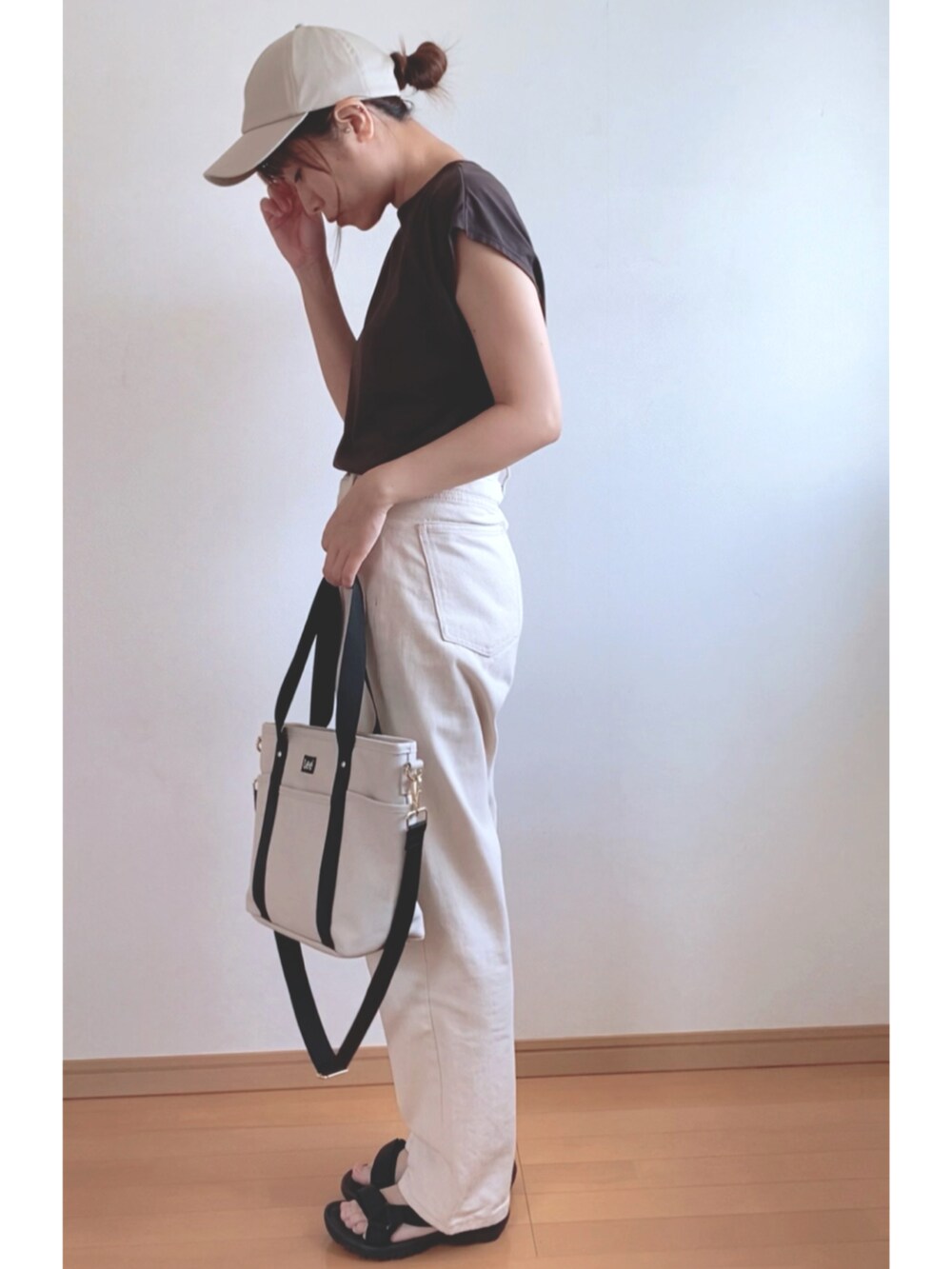 ブラウン系のTシャツ/カットソー、ベージュ系のトートバッグ、ブラック系のサンダルを着用したレディースの夏コーディネートの2枚目の写真