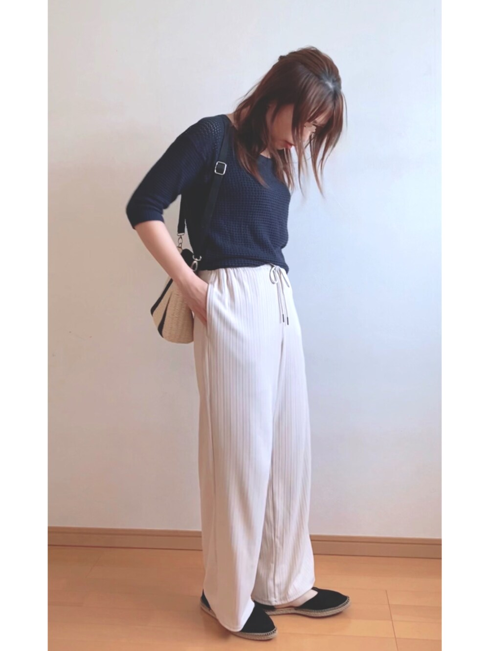 ブルー系のニット/セーター、ベージュ系のショルダーバッグ、ホワイト系のその他パンツを着用したレディースの夏コーディネートの2枚目の写真