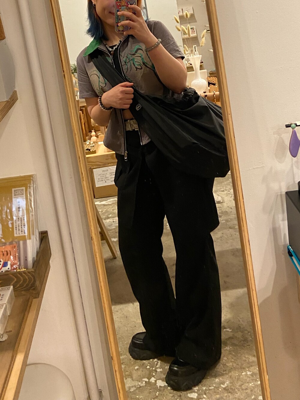 グレー系のTシャツ/カットソー、ブラック系のスラックスを着用したレディースの秋コーディネートの4枚目の写真