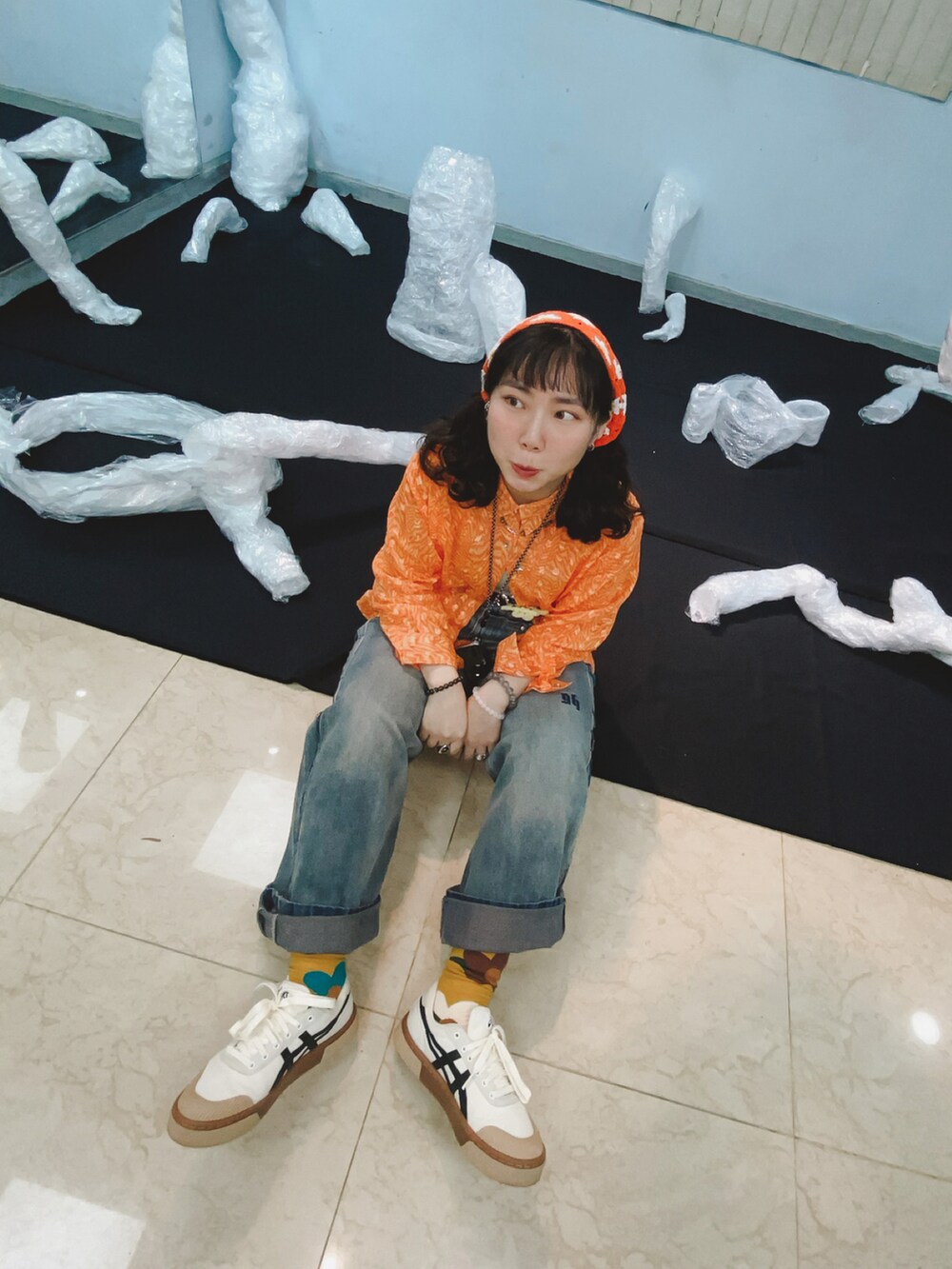 ベージュ系のスニーカー、グレー系のデニムパンツを着用したレディースの春コーディネートの2枚目の写真