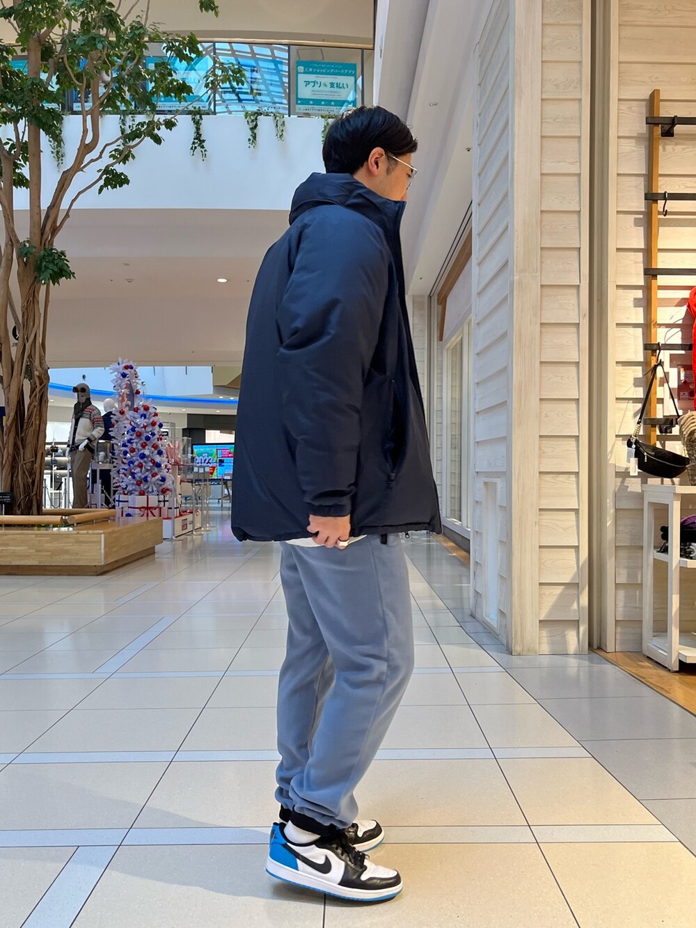 ブルー系のその他パンツ、ブルー系のダウンジャケット/コート、グレー系のスウェットを着用したメンズの冬コーディネートの2枚目の写真