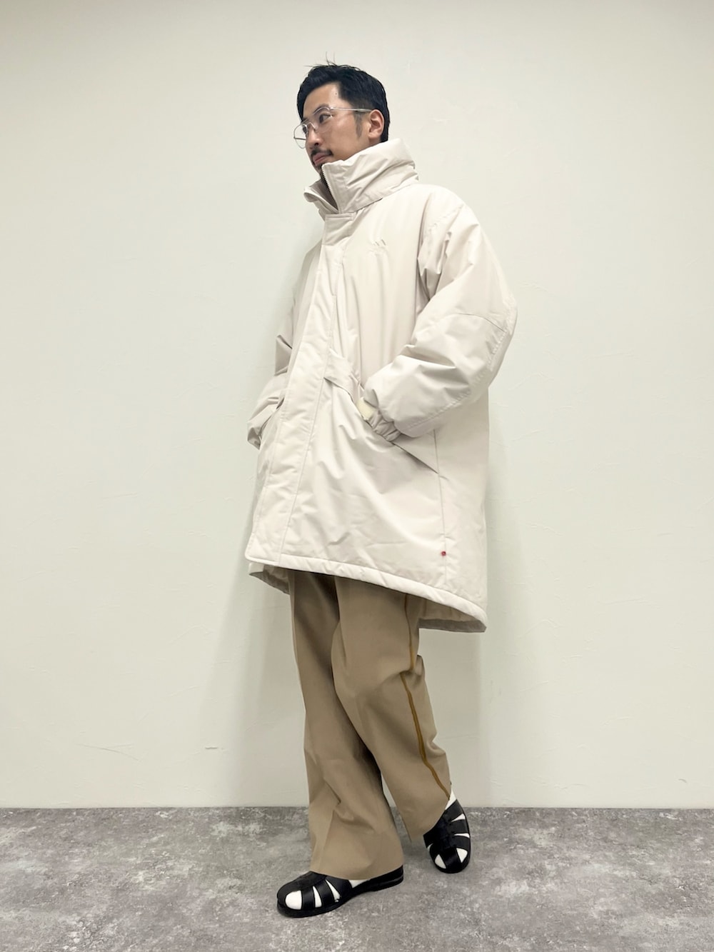 ホワイト系のTシャツ/カットソー、ホワイト系のその他アウター、ブラック系のサンダルを着用したメンズの秋コーディネートの2枚目の写真