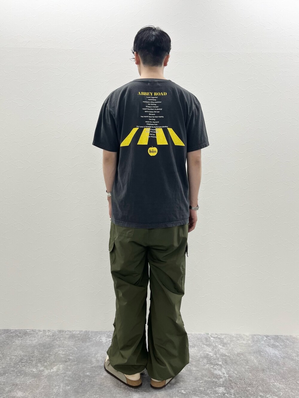 ブラック系のTシャツ/カットソー、グリーン系のカーゴパンツを着用したメンズの春コーディネートの2枚目の写真