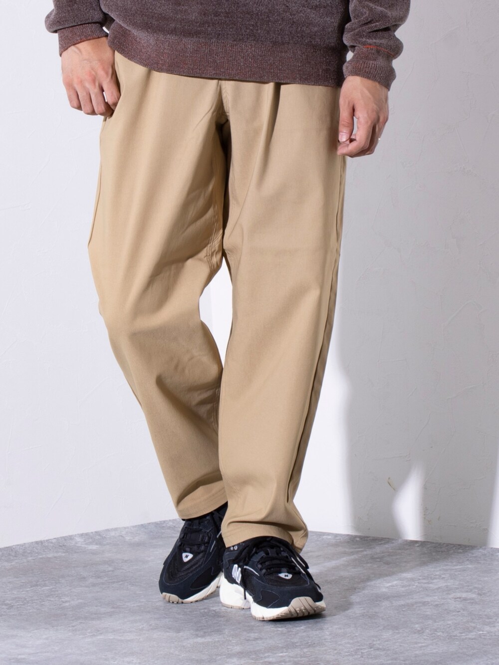 ブラック系のスニーカー、ベージュ系のその他パンツ、ブラウン系のニット/セーターを着用したメンズの秋コーディネートの3枚目の写真