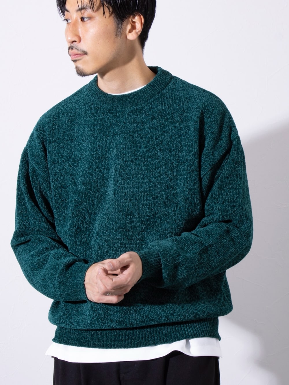 グリーン系のニット/セーター、ブラック系のスラックスを着用したメンズの秋コーディネートの2枚目の写真