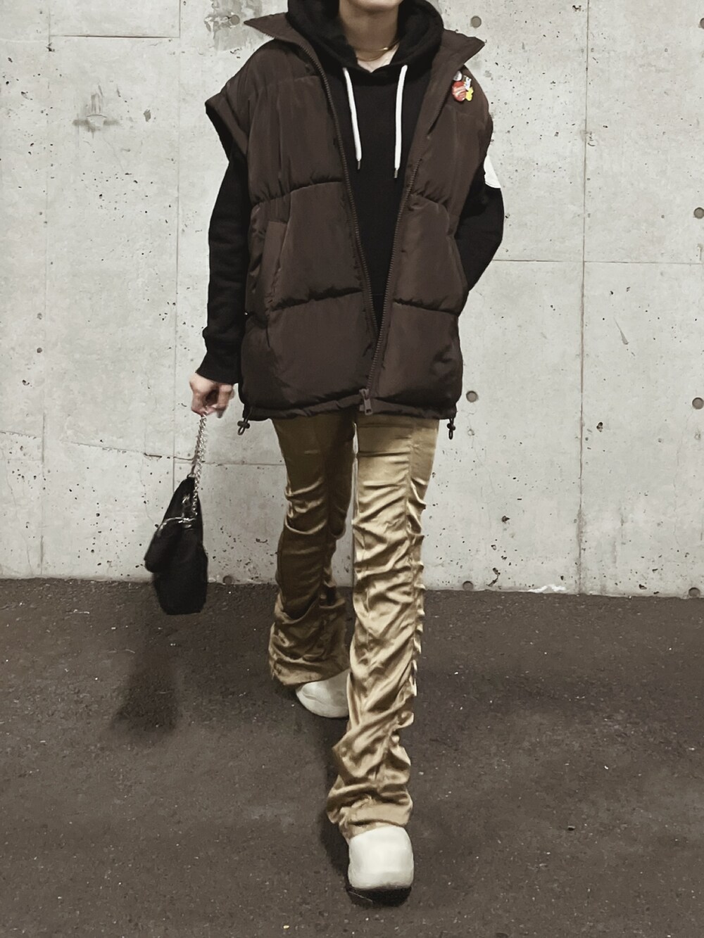 ホワイト系のブーツ、ゴールド系のその他パンツ、ブラック系のパーカーを着用したレディースの秋コーディネートの2枚目の写真