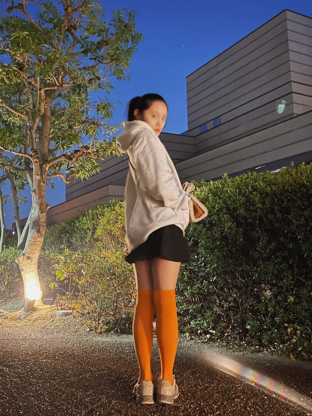 ベージュ系のスニーカー、ブラック系のスカート、グレー系のスウェットを着用したレディースの冬コーディネートの2枚目の写真