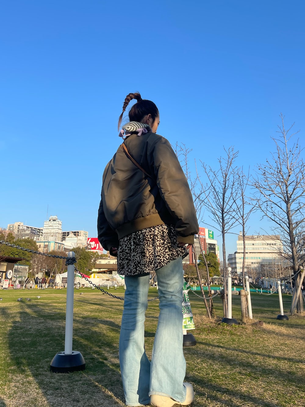 ブルー系のデニムパンツ、ホワイト系のブーツ、その他のワンピース/ドレスを着用したレディースの冬コーディネートの2枚目の写真