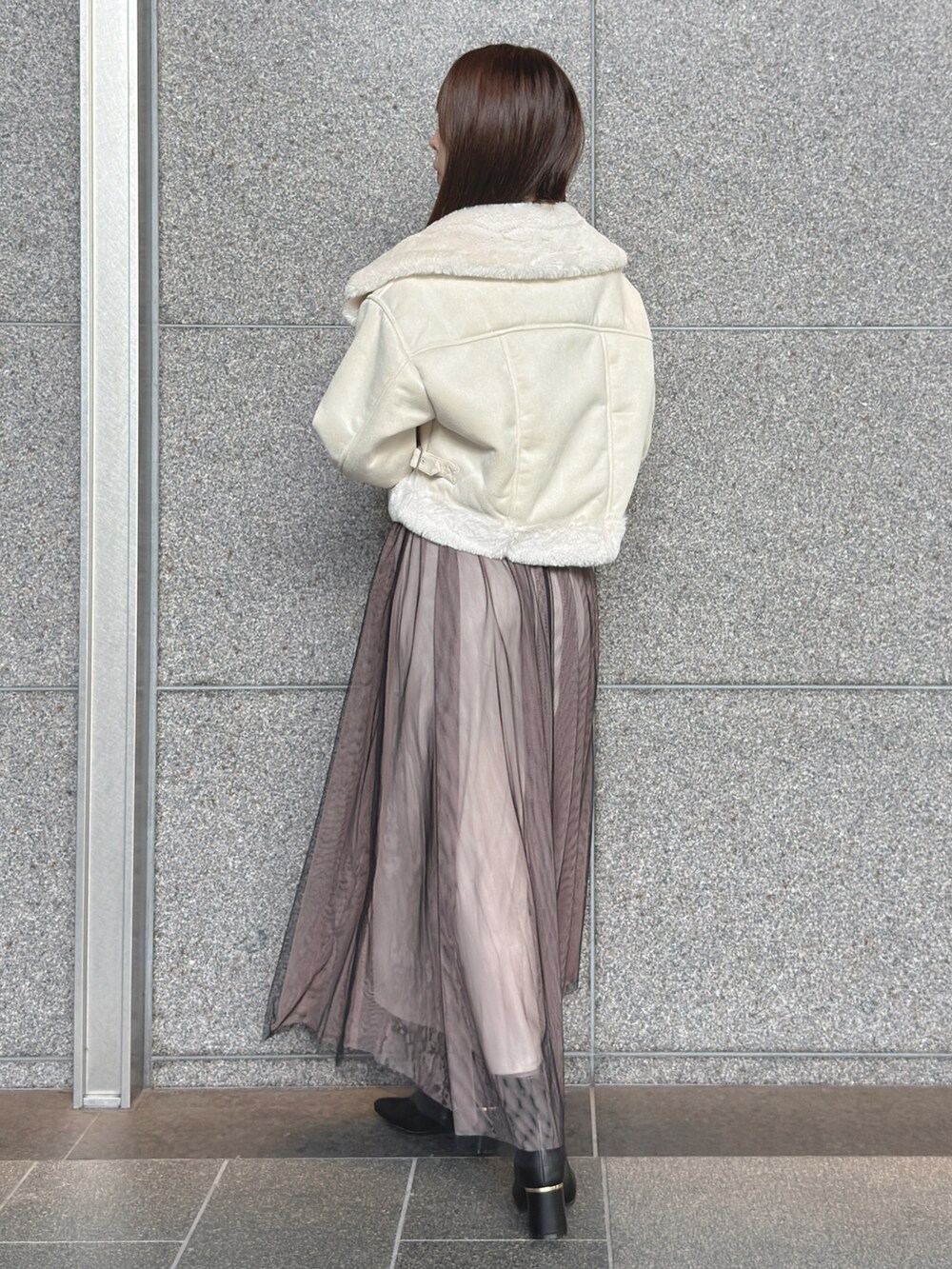 ホワイト系のムートンコート、ブラック系のワンピース、ブラック系のブーツを着用したレディースの秋コーディネートの5枚目の写真