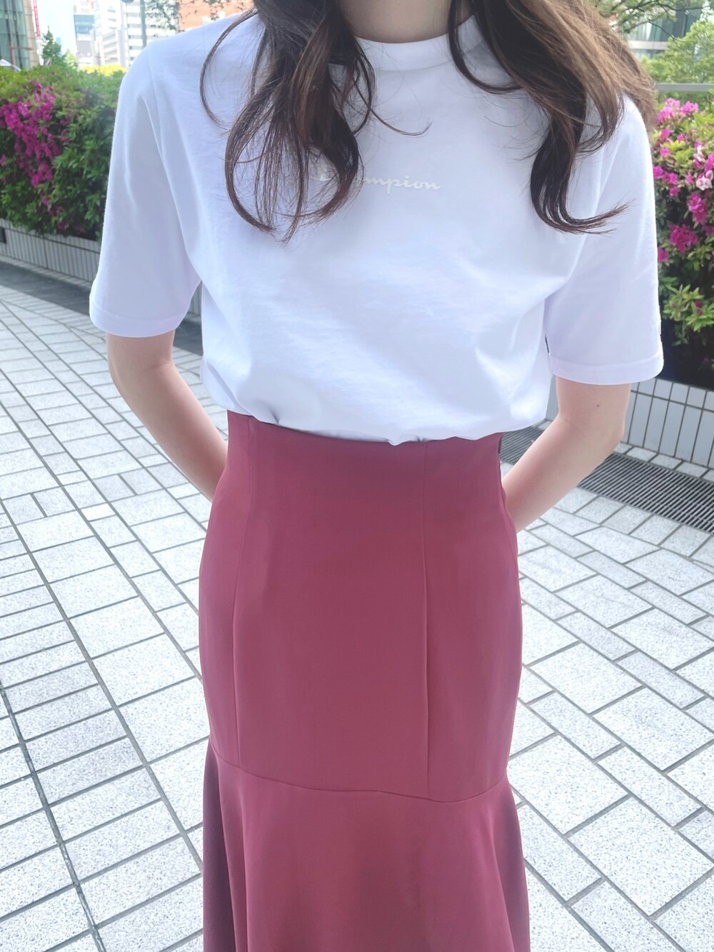 ピンク系のスカート、ホワイト系のTシャツ/カットソー、ブラック系のサンダルを着用したレディースの春コーディネートの4枚目の写真