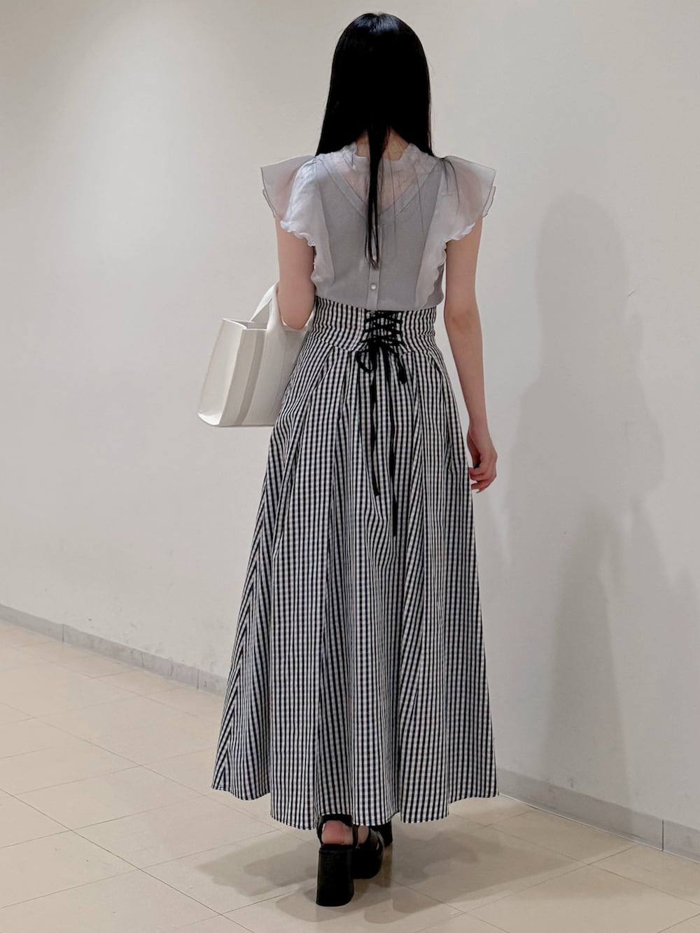 グレー系のニット/セーター、その他のスカート、ホワイト系のトートバッグを着用したレディースの春コーディネートの5枚目の写真