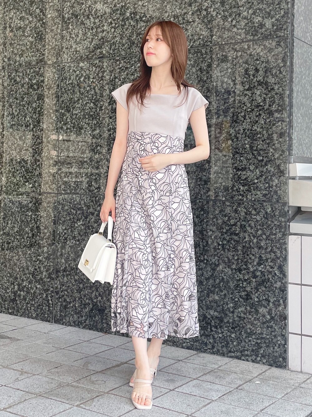 ベージュ系のワンピース、ホワイト系のハンドバッグ、その他のサンダルを着用したレディースの夏コーディネートの2枚目の写真