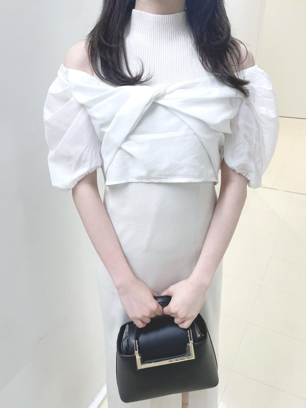 ホワイト系のワンピース、ブラック系のハンドバッグ、ホワイト系のブーツを着用したレディースの春コーディネートの7枚目の写真