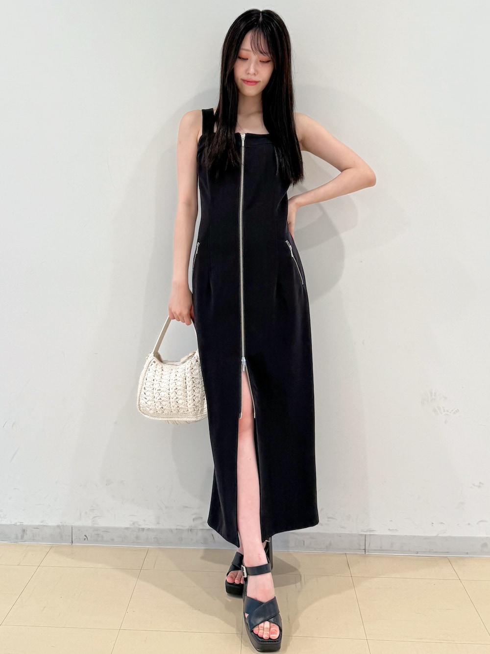 ブラック系のワンピース、ホワイト系のショルダーバッグ、ブラック系のサンダルを着用したレディースの夏コーディネートの2枚目の写真