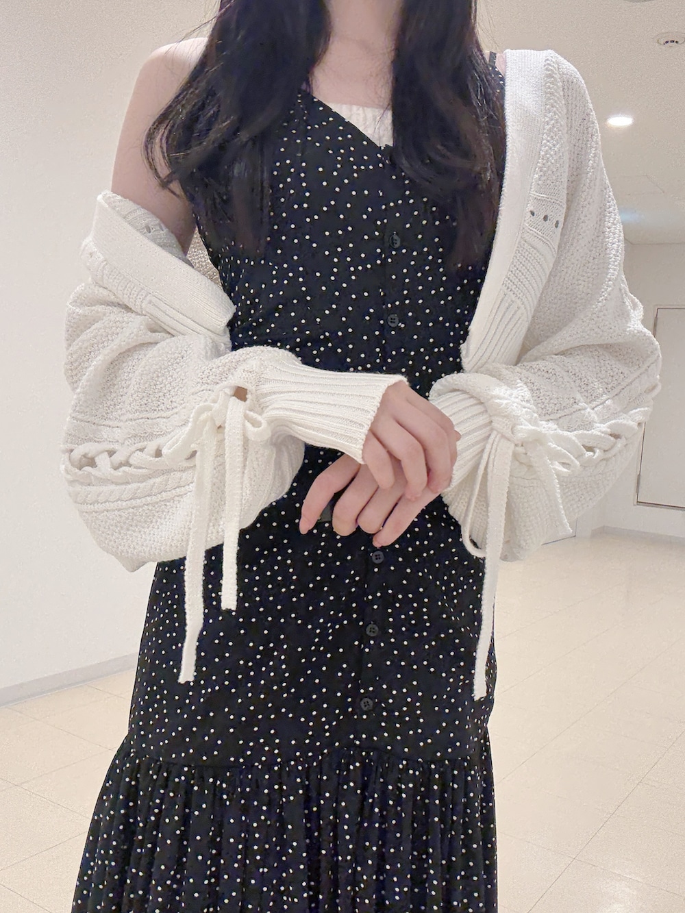 ブラック系のワンピース、ホワイト系のカーディガン/ボレロ、ホワイト系のパンプスを着用したレディースの秋コーディネートの5枚目の写真