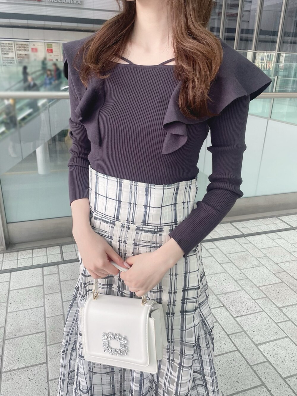 ホワイト系のショルダーバッグ、グレー系のニット/セーター、ホワイト系のチェスターコートを着用したレディースの冬コーディネートの6枚目の写真