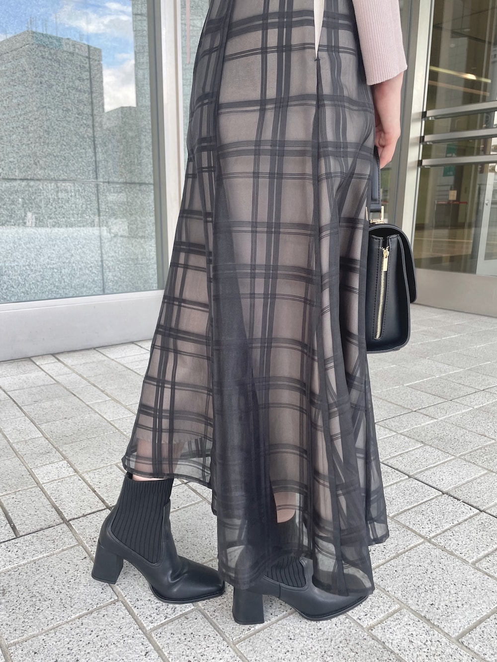 ピンク系のワンピース、ブラック系のショルダーバッグ、ブラック系のブーツを着用したレディースの秋コーディネートの7枚目の写真