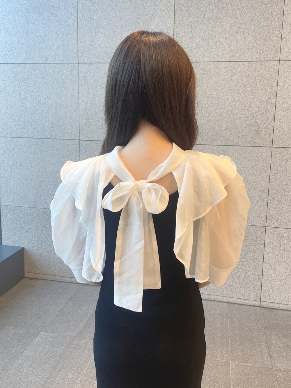 ブラック系のワンピース、シルバー系のハンドバッグ、ブラック系のブーツを着用したレディースの夏コーディネートの6枚目の写真