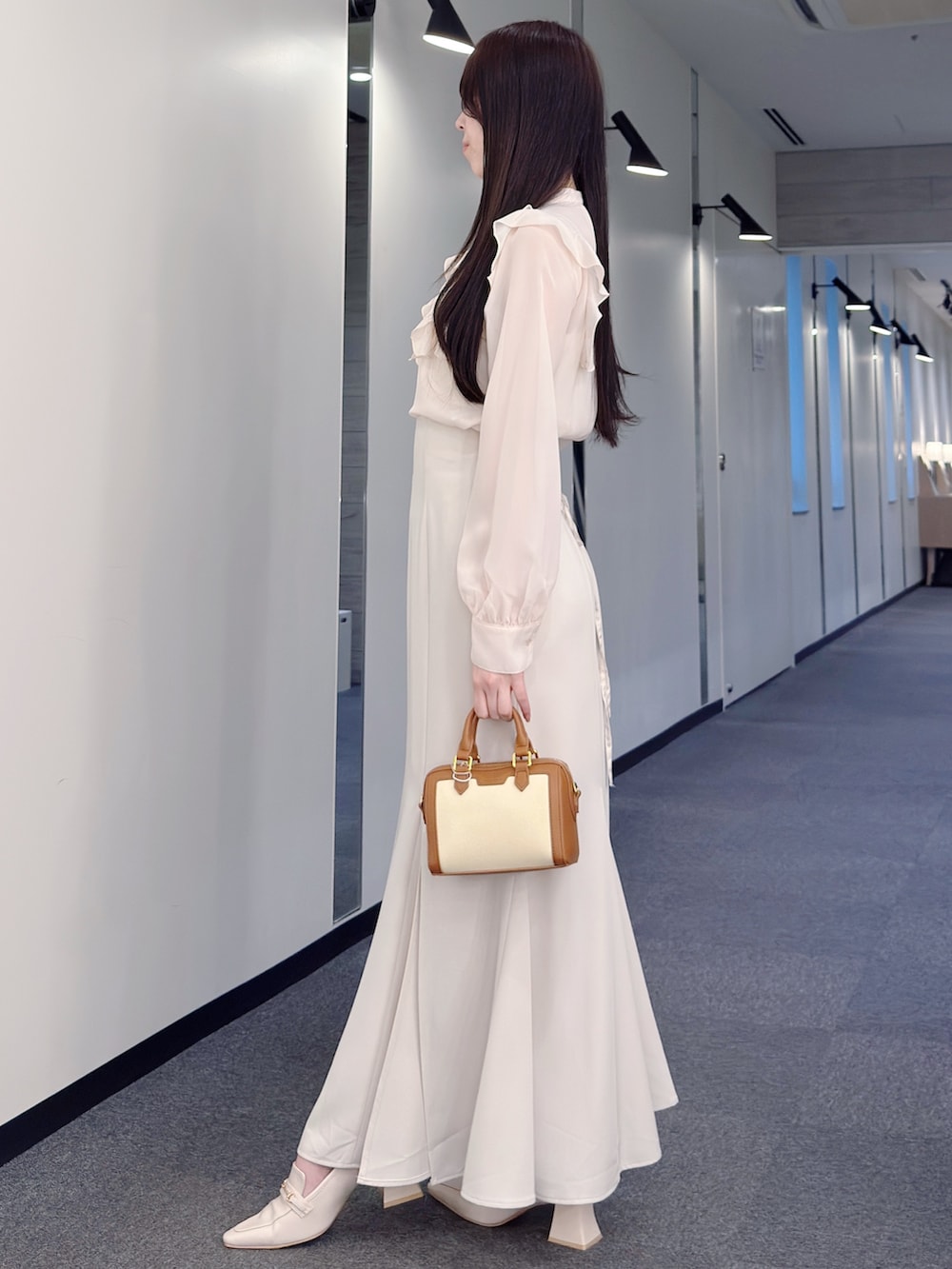 ピンク系のシャツ/ブラウス、ホワイト系のスカート、ブラウン系のハンドバッグを着用したレディースの春コーディネートの4枚目の写真