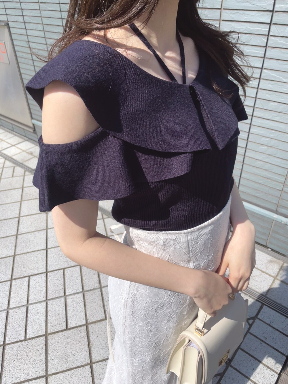 ブルー系のニット/セーター、ホワイト系のスカート、ホワイト系のハンドバッグを着用したレディースの春コーディネートの7枚目の写真