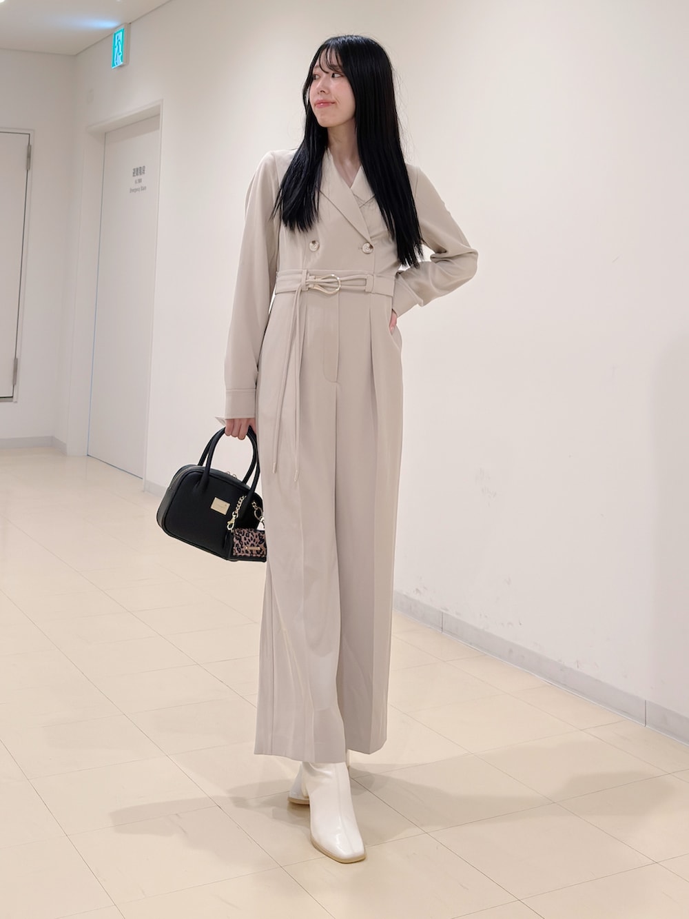 ベージュ系のつなぎ/オールインワン、ブラック系のハンドバッグ、ホワイト系のブーツを着用したレディースの秋コーディネートの2枚目の写真