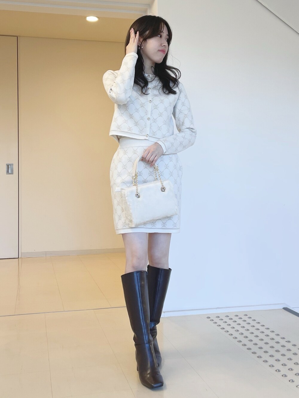 ホワイト系のワンピースを着用したレディースの冬コーディネートの2枚目の写真