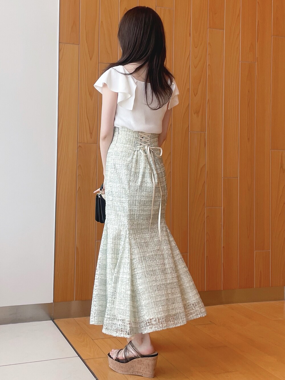 ベージュ系のシャツ/ブラウス、ホワイト系のニット/セーター、グリーン系のスカートを着用したレディースの春コーディネートの7枚目の写真