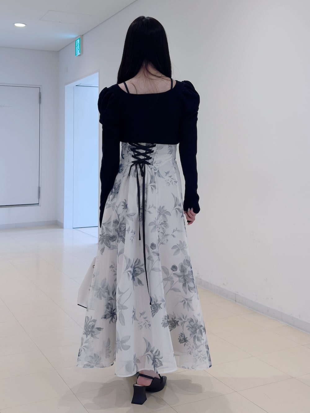 ブルー系のニット/セーター、ホワイト系のスカート、ホワイト系のショルダーバッグを着用したレディースの冬コーディネートの4枚目の写真