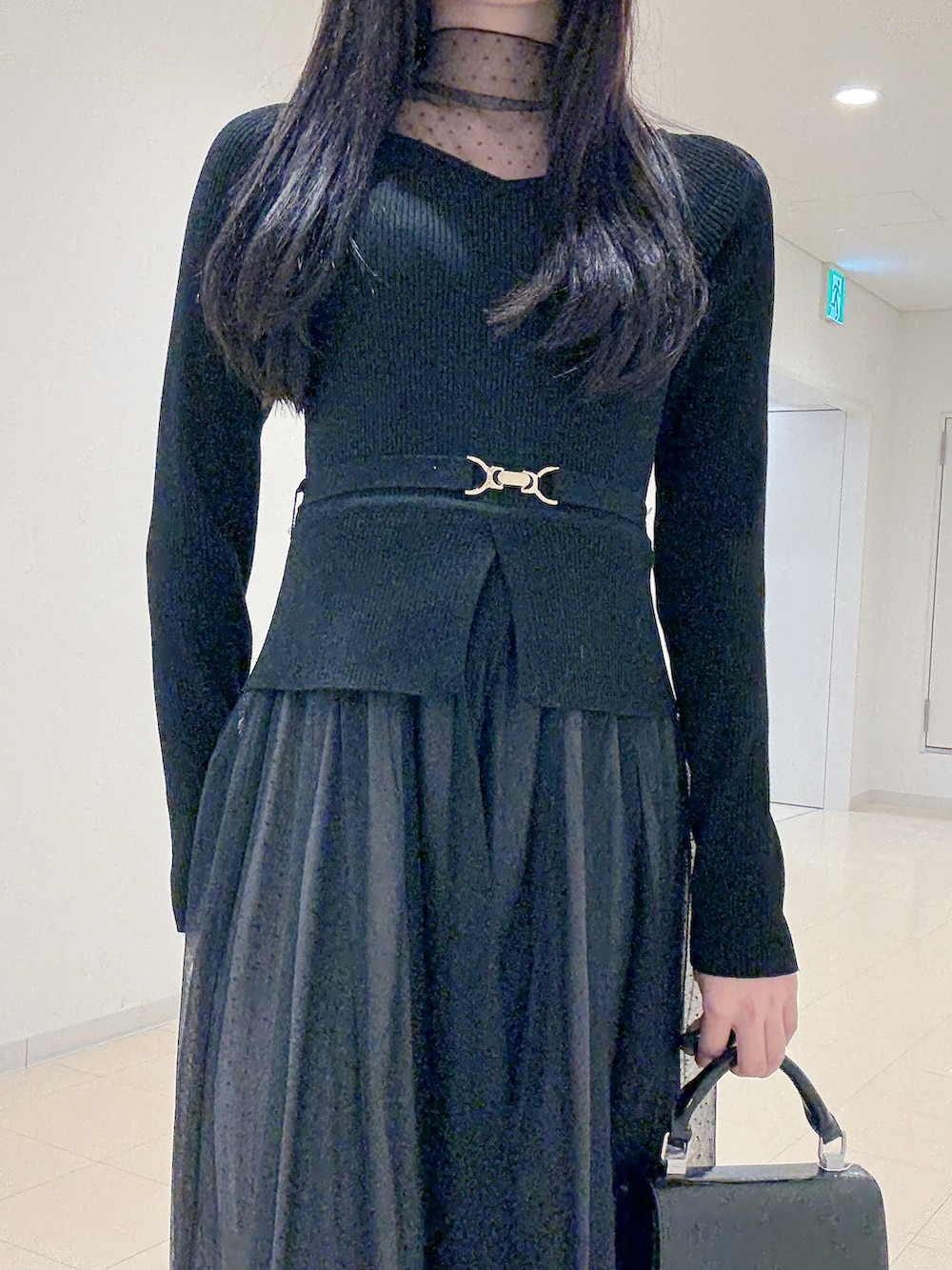 ブラック系のワンピース、ブラック系のハンドバッグ、ブラウン系のブーツを着用したレディースの秋コーディネートの6枚目の写真