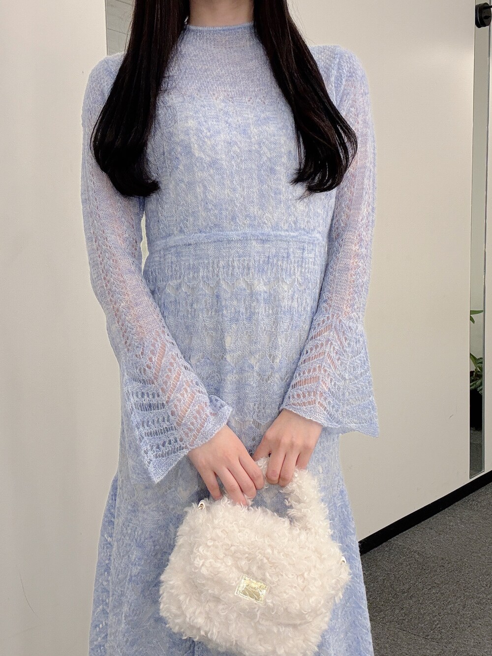 ブルー系のワンピース、ホワイト系のハンドバッグ、ホワイト系のパンプスを着用したレディースの秋コーディネートの6枚目の写真