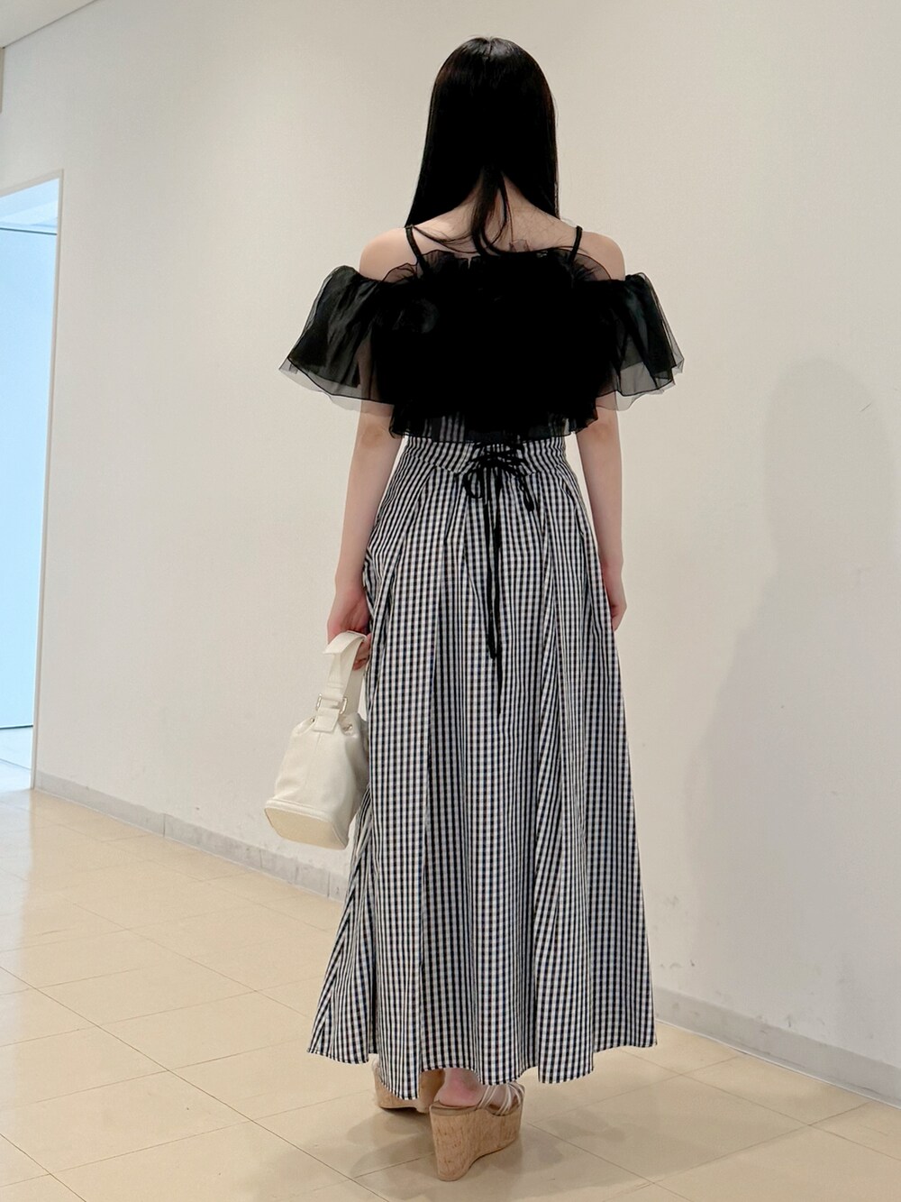 ブラック系のシャツ/ブラウス、その他のスカート、ホワイト系のハンドバッグを着用したレディースの春コーディネートの5枚目の写真