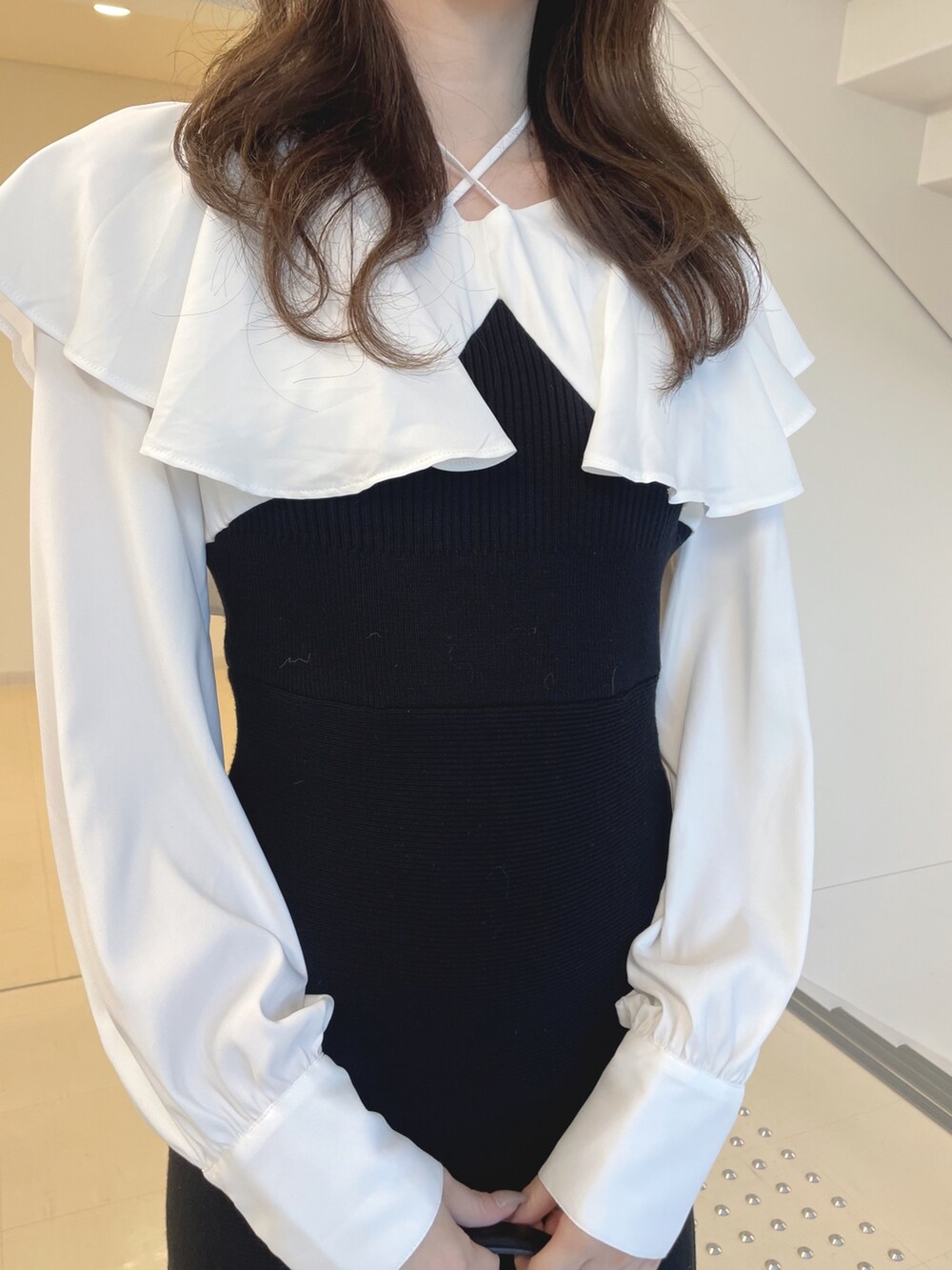 ホワイト系のブーツ、ブラック系のショルダーバッグ、ブラック系のワンピースを着用したレディースの秋コーディネートの5枚目の写真