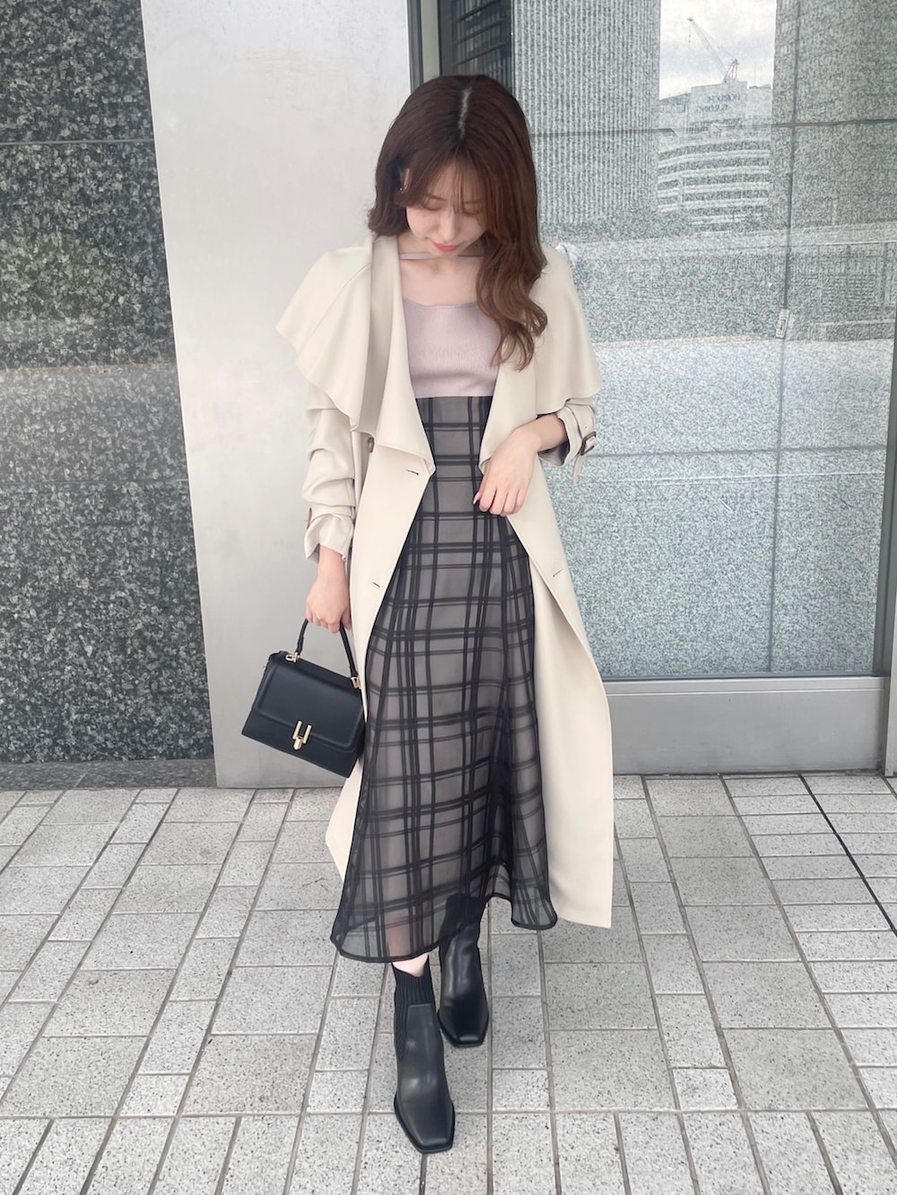 ピンク系のワンピース、ベージュ系のトレンチコート、ブラック系のショルダーバッグを着用したレディースの秋コーディネートの5枚目の写真