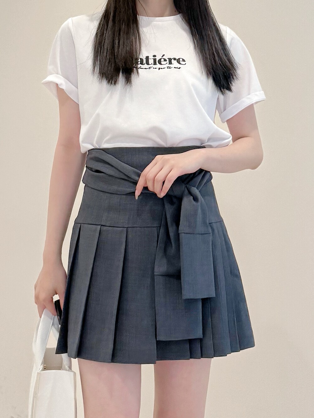ホワイト系のTシャツ/カットソー、グレー系のスカート、ホワイト系のトートバッグを着用したレディースの春コーディネートの6枚目の写真