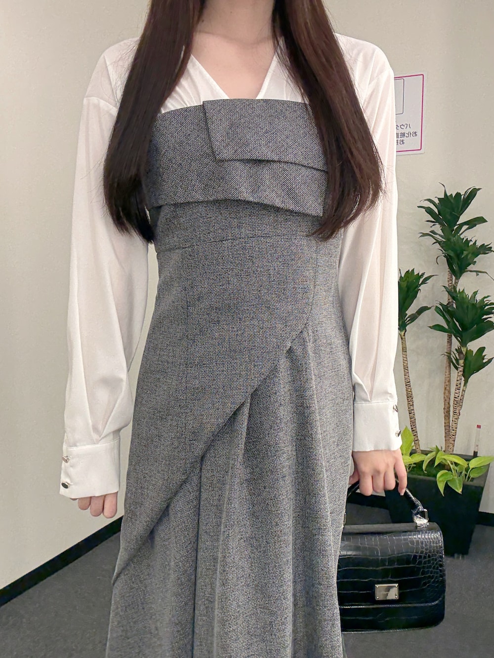 ブラック系のワンピース、ブラック系のハンドバッグ、ホワイト系のパンプスを着用したレディースの春コーディネートの5枚目の写真