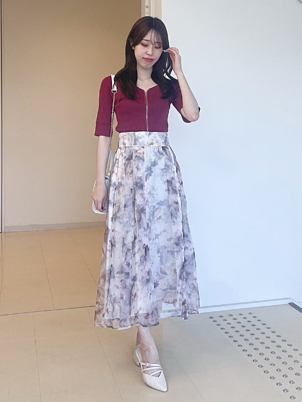 ピンク系のニット/セーター、ホワイト系のスカート、ホワイト系のショルダーバッグを着用したレディースの夏コーディネートの3枚目の写真